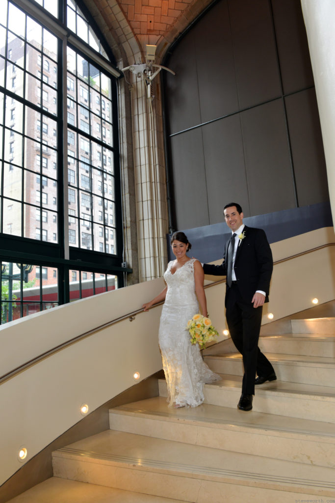 Bride and Groom walking down the Spiral Stairs by: Kira Yustak