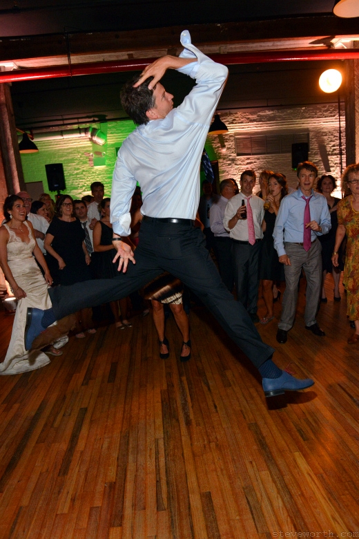 Bride watches Dancing Guest Leap – Liberty Warehouse by: Steve Worth Photography