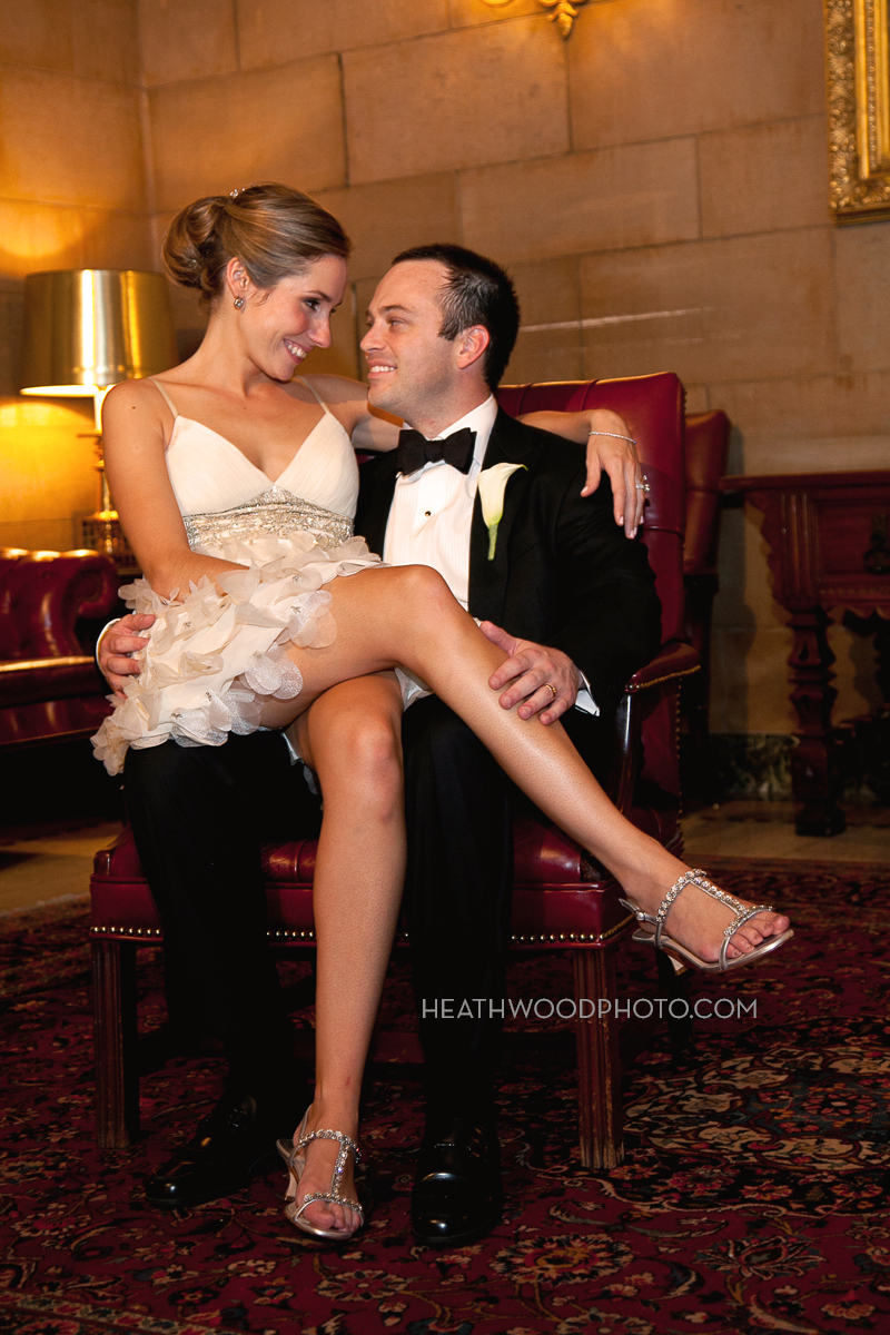 Bride sitting on groom’s lap in lobby by: Heathwood Photo