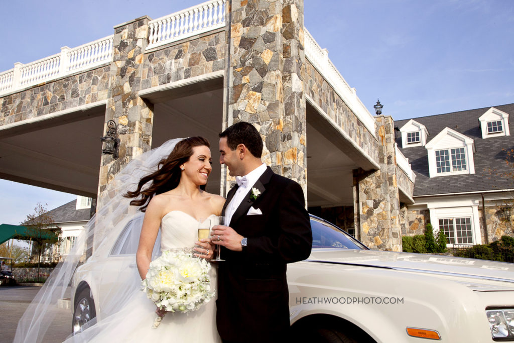 Bride and Groom toast next to Rolls Royce in front by: Heathwood Photo