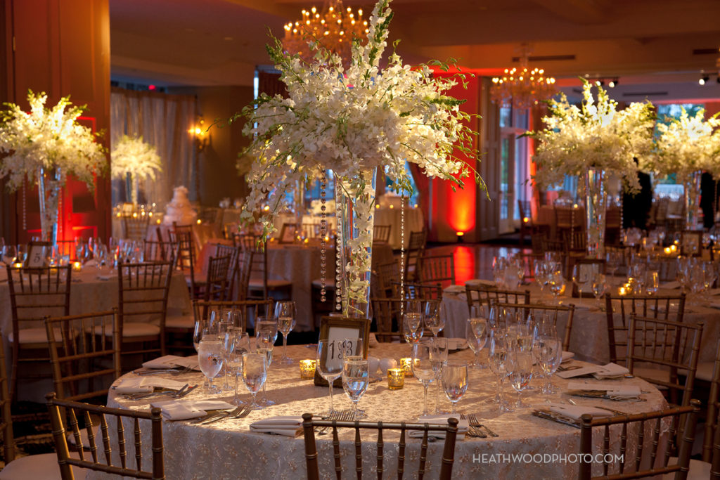 Ballroom tables with floral centerpieces set for reception by: Heathwood Photo