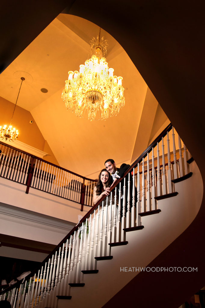 Bride and groom on grand staircase by: Heathwood Photo