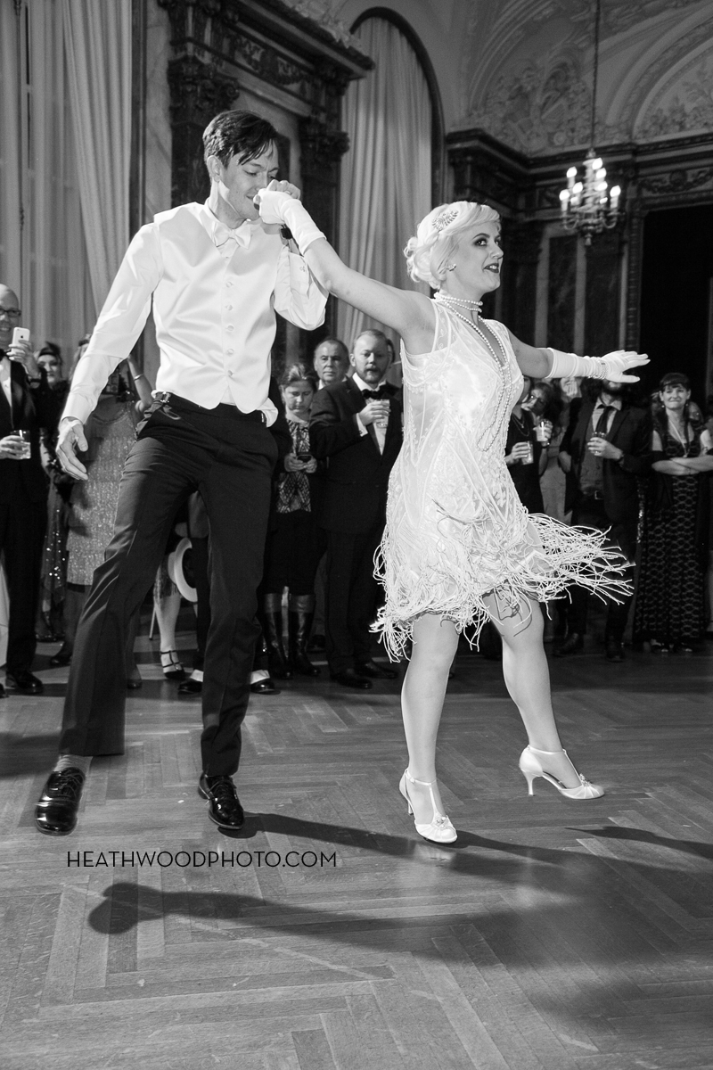 Groom and bride in her “flapper” dress do a happy dance by: Heathwood Photo
