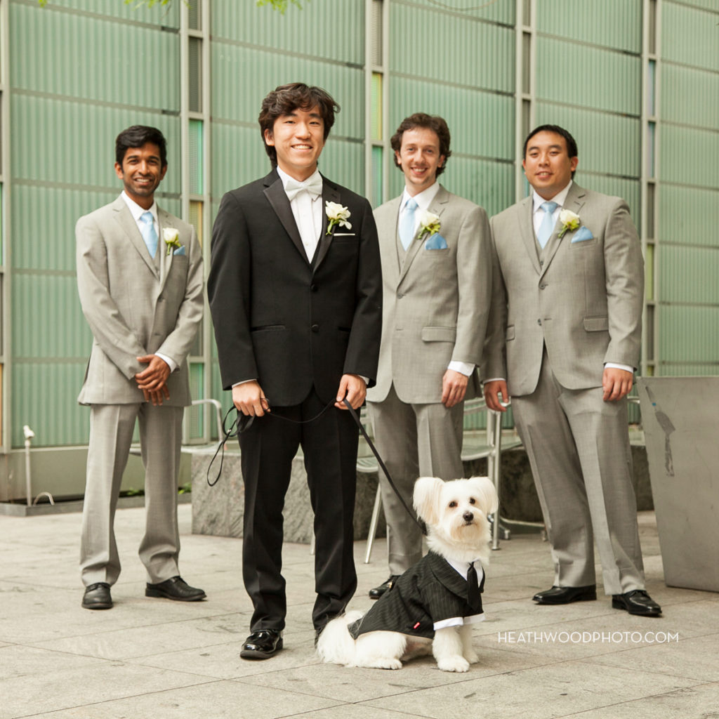 Groom with his men and dog in green space adjacent to hotel by: Heathwood Photo