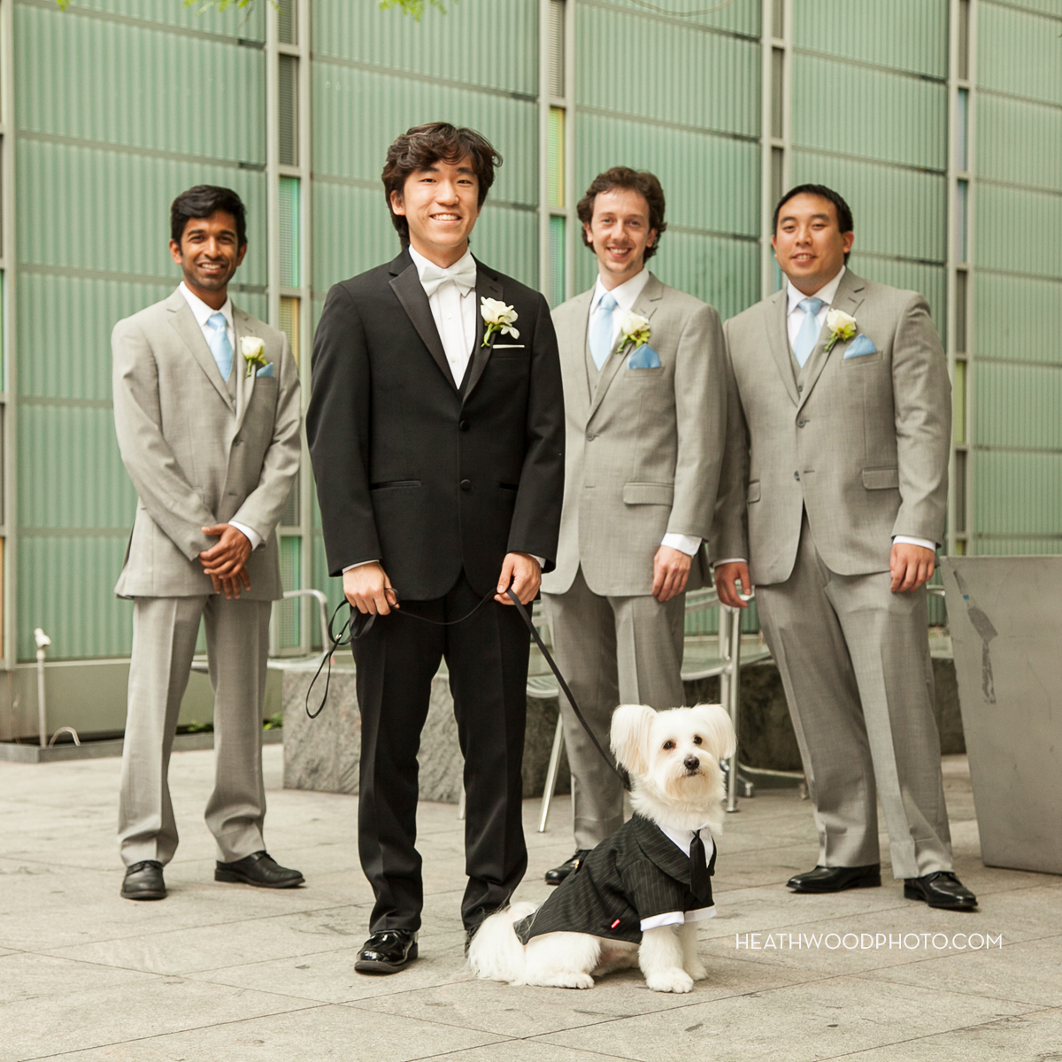 Groom with his men and dog in green space adjacent to hotel by: Heathwood Photo