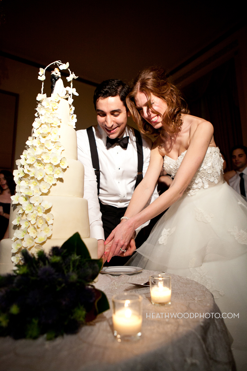 Bride and groom cut wedding cake by: Heathwood Photo
