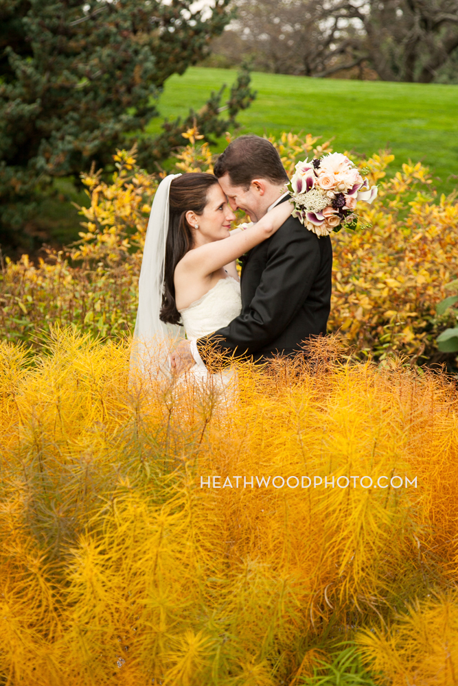 Bride and Groom canoodle in garden by: Heathwood Photo